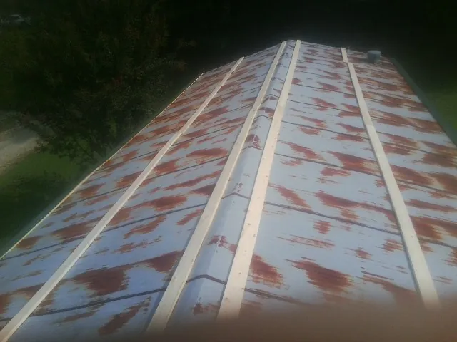 Rusted metal roof panels with new wood purlins before replacement — Storm Damage Roof Repair in Sinclair by Roofing Brothers