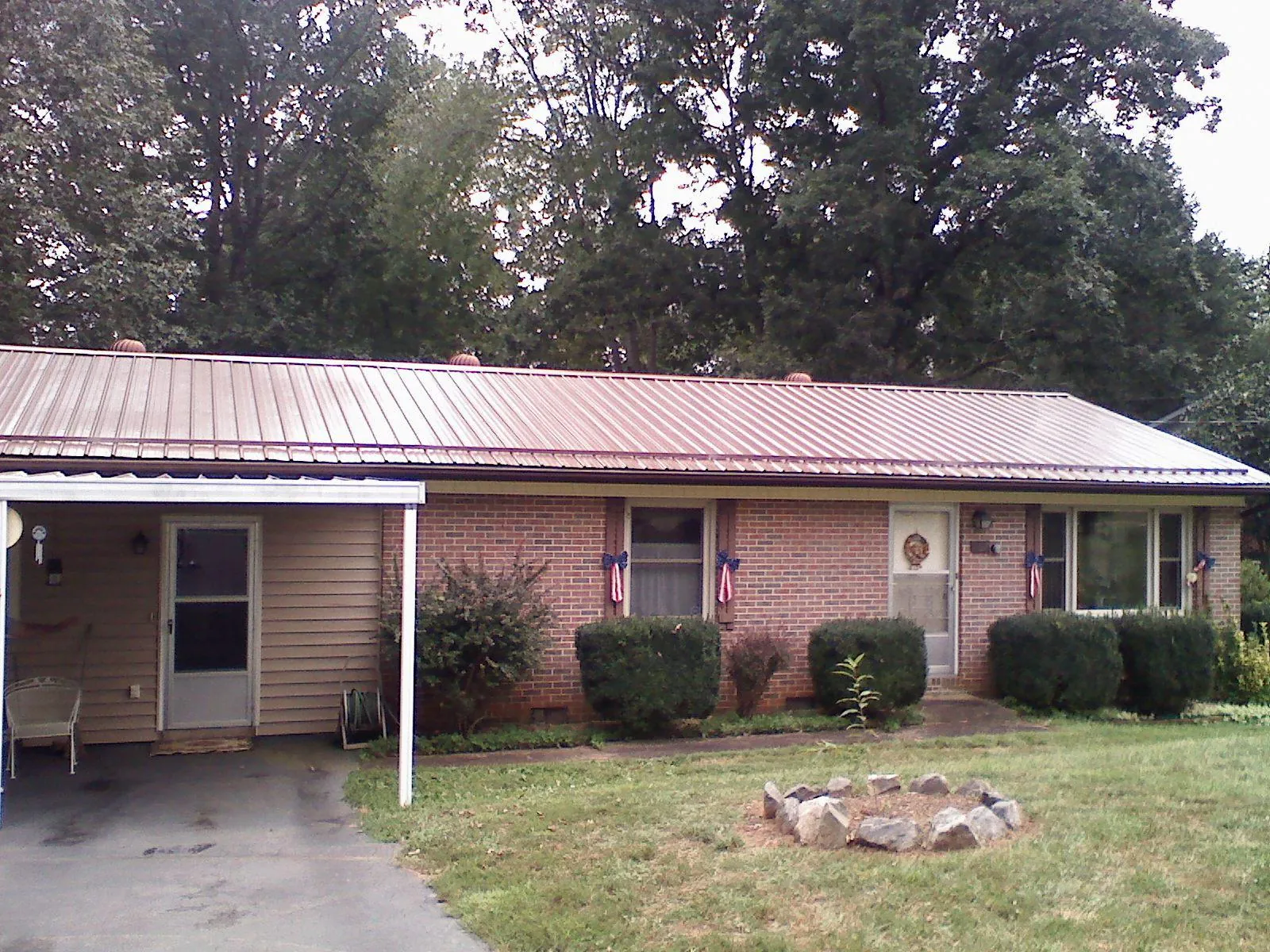 Bronze metal roof and carport on a brick ranch home — Roof Repair work by our crew in Sinclair