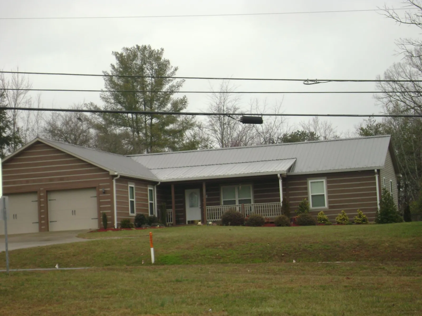 Gray metal roof on a log sided ranch home with a front porch in Sinclair